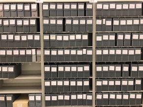 Image of archived catalogs on grey metal shelves